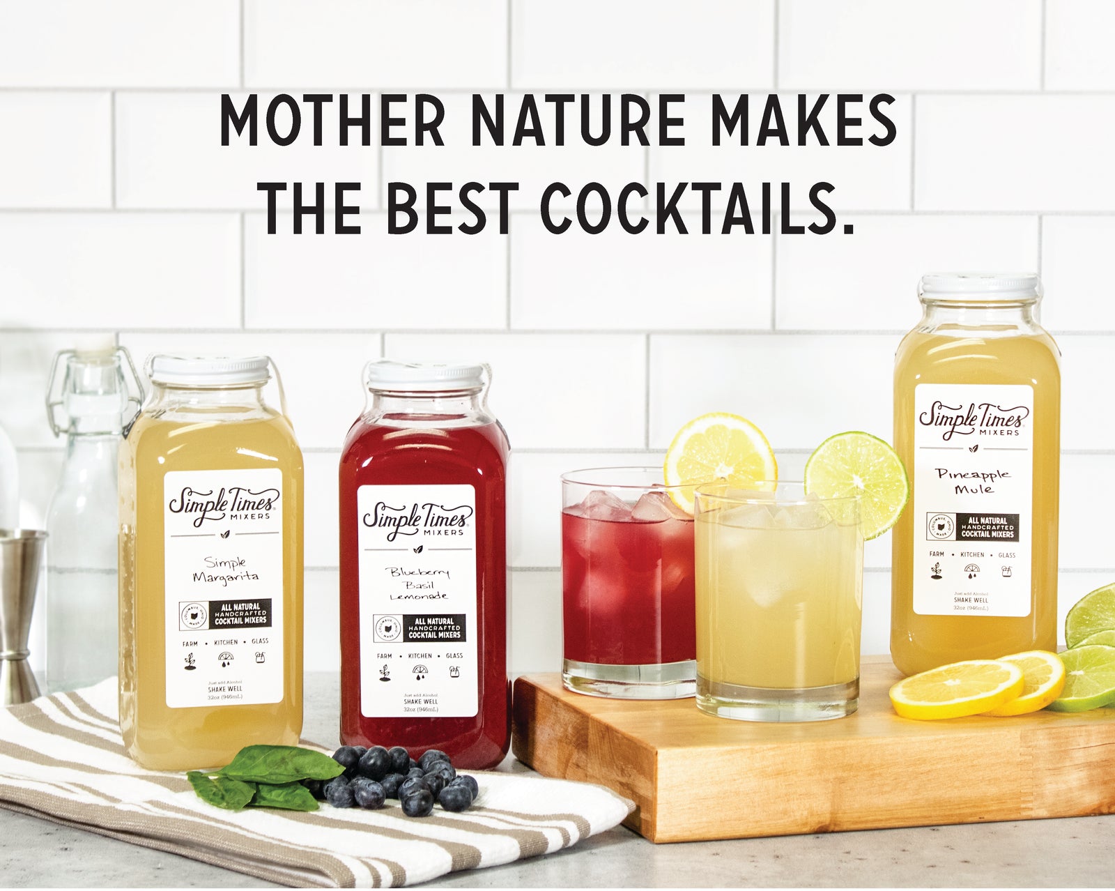 Front view of three Simple Times Mixers bottles and two cocktails showing labels and fruit garnishes, tiled kitchen background, headline 'Mother Nature makes the best cocktails'
