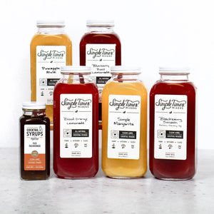 Front view of Build Your Bar Bundle six pack showcasing six flavored mixers and Old Fashioned syrup on a light countertop