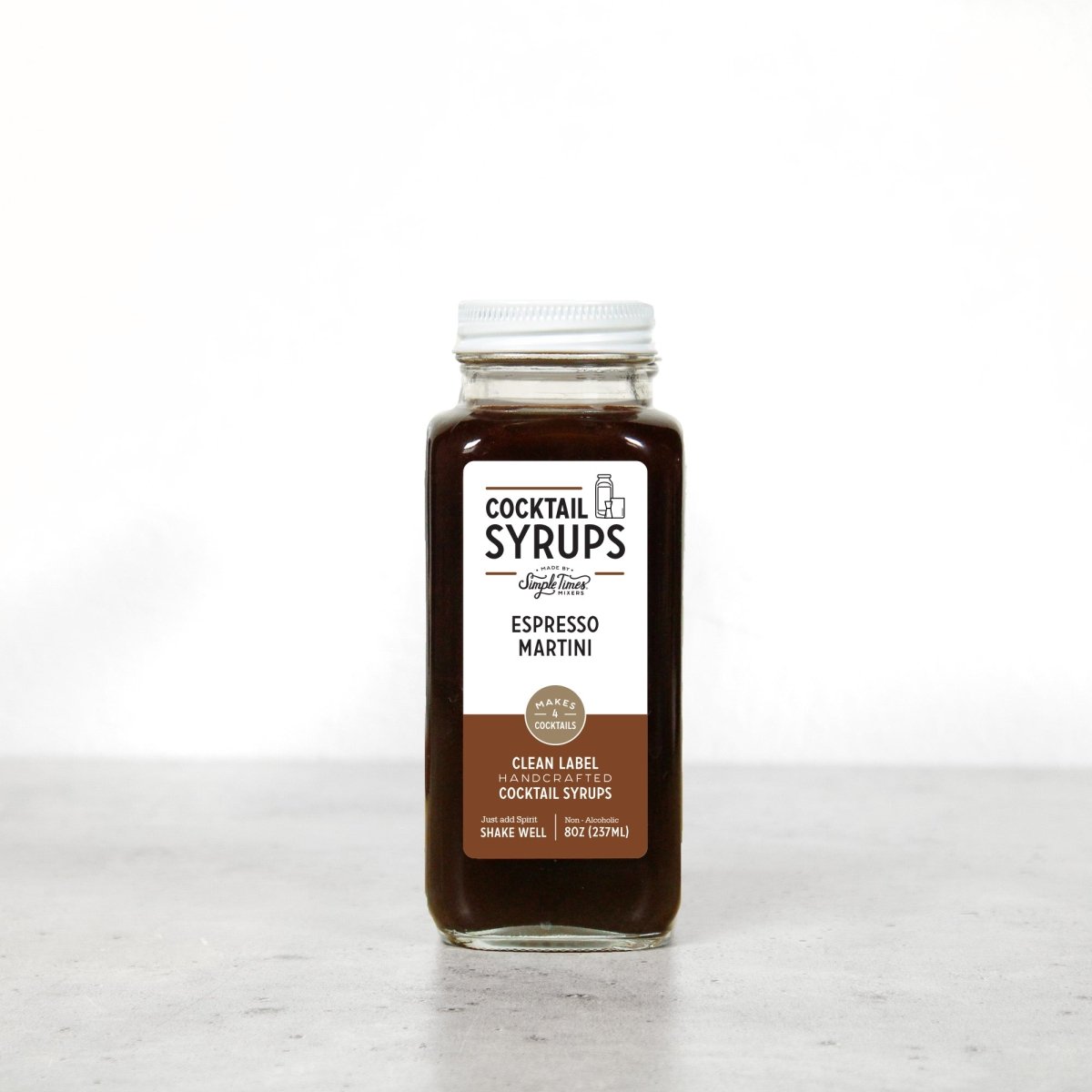 Front view of Espresso Martini Cocktail Syrup bottle showcasing dark brown syrup on a white background