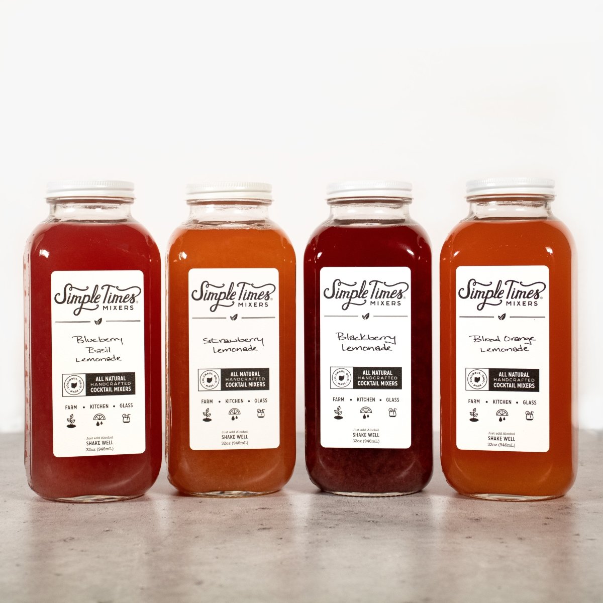 Front view of Lemonade Bundle with four flavored lemonade mixer bottles on a light background