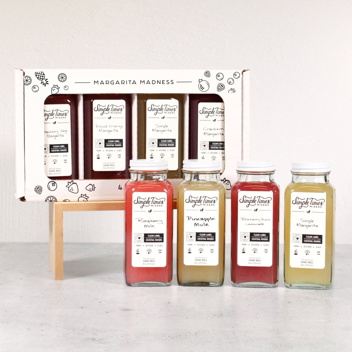 Front view of Sampler Pack showcasing assorted cocktail mixer bottles and a boxed set on a light background