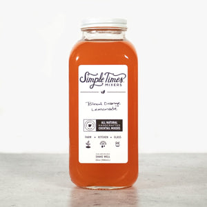 Front view of Blood Orange Lemonade cocktail mixer bottle showcasing its orange color with a light background