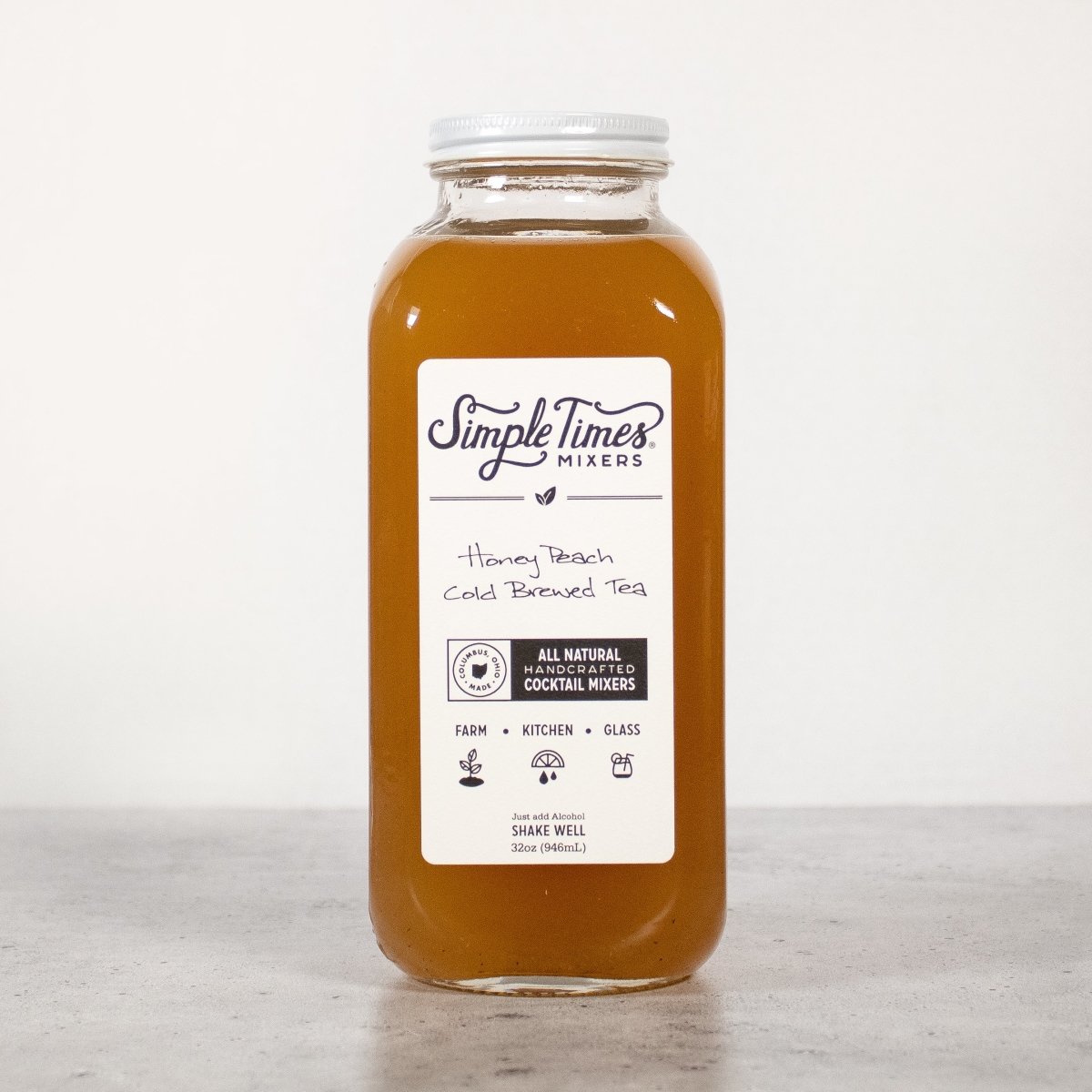 Front view of Honey Peach Cold Brewed Tea bottle showcasing amber cocktail mixer and 32-ounce label against a light background