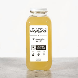 Front view of Pineapple Mule cocktail mixer bottle showcasing its yellow pineapple mixer with a white label on a light background